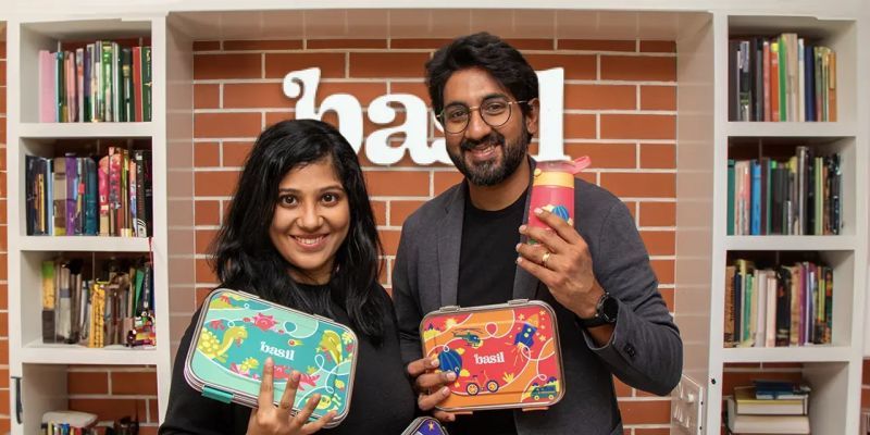 Mahesh Muraleedharan and Harini Rajagopalan holding Basil products in front of the Basil logo for the funding note.